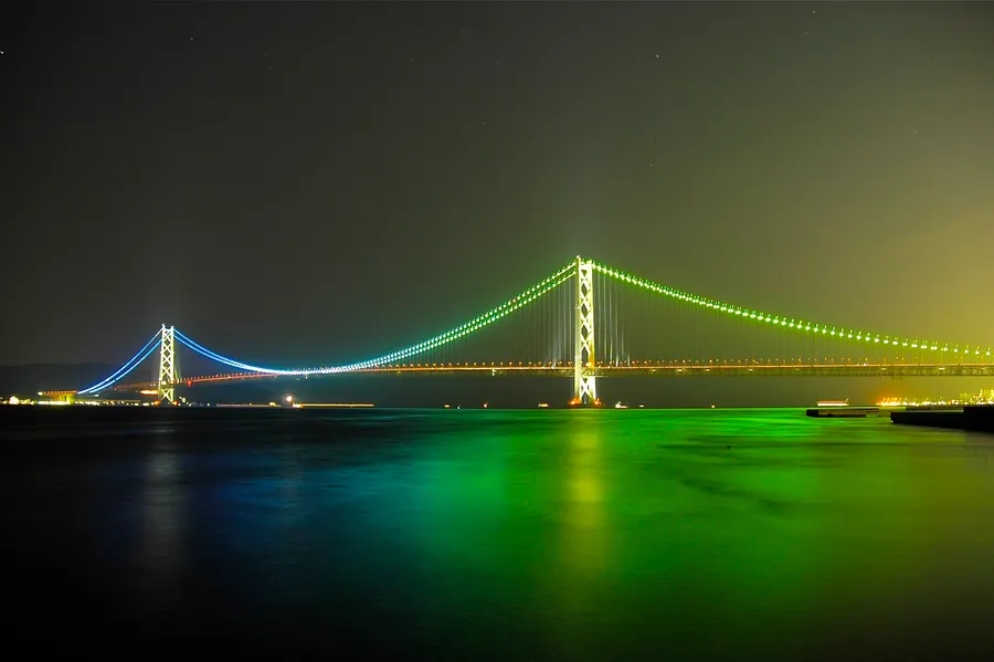 The Akashi Kaikyō Bridge lit up at night, seen from Maiko, 2006.