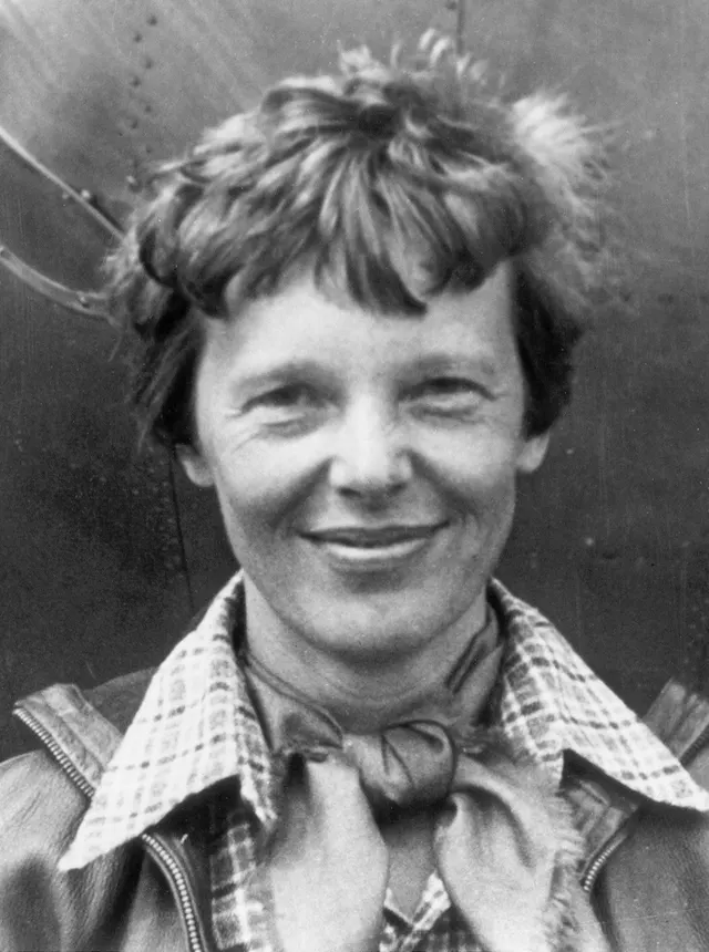 Amelia Earhart in 1937, standing under the nose of her Lockheed Electra (National Portrait Gallery, Smithsonian).