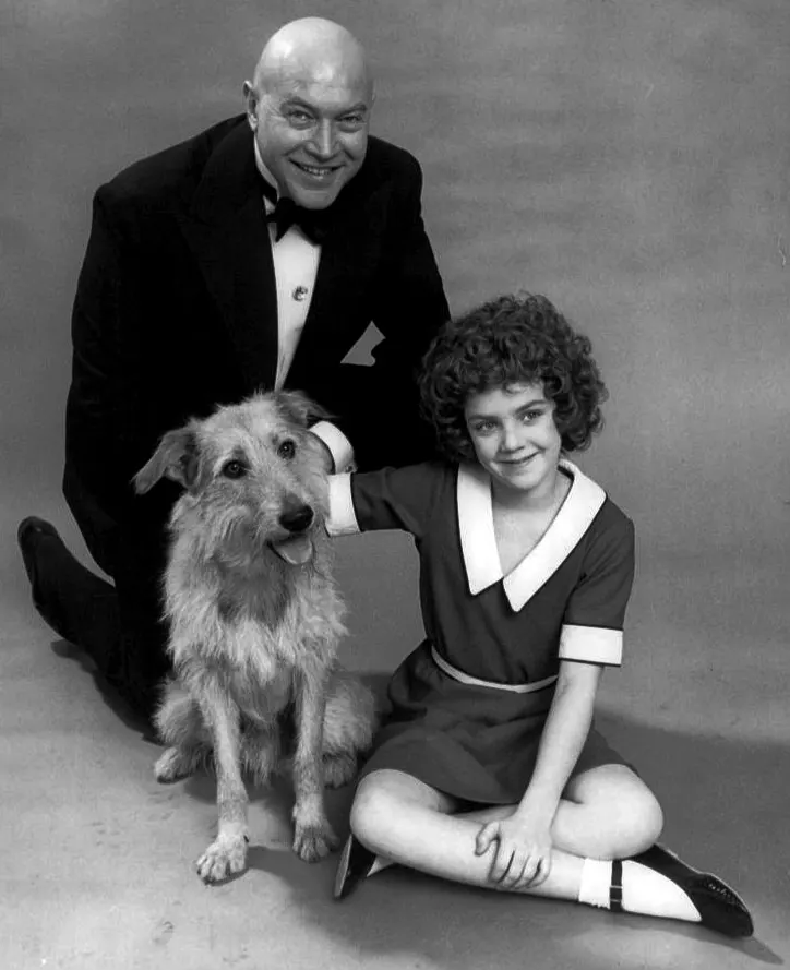 Andrea McArdle as Annie, with Reid Shelton as Daddy Warbucks and Sandy the dog, in a 1977 publicity photograph.