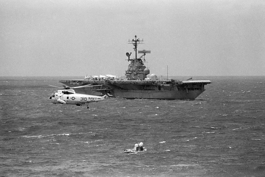 The recovery ship USS Hornet moves towards the floating Apollo 12 command module, 24 November 1969.