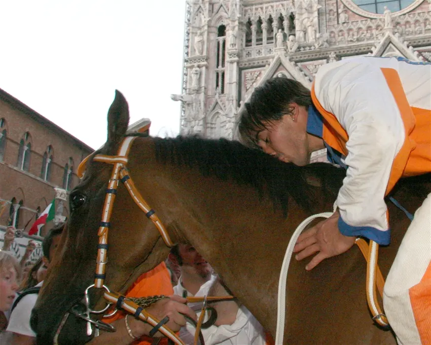Jockey Jonatan Bartoletti kisses his horse Brento after winning the Palio dell'Assunta in Siena in 2007