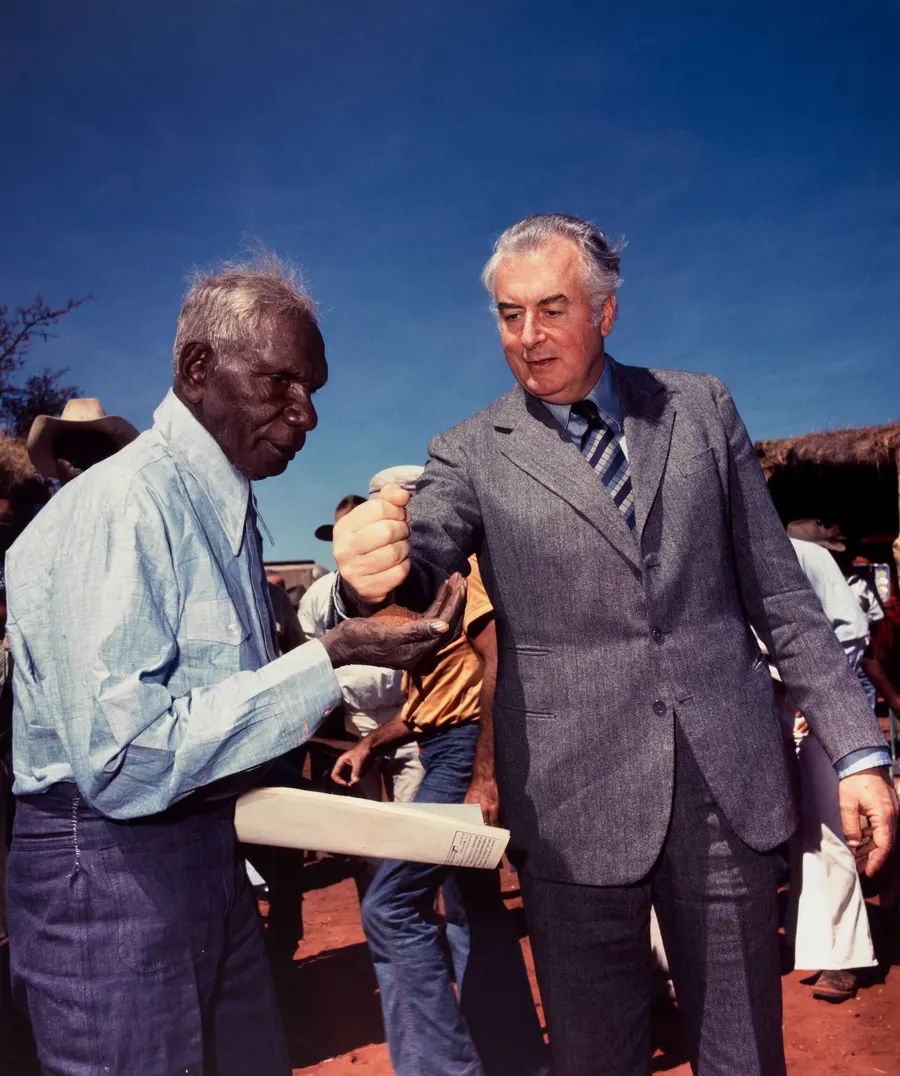 Prime Minister Gough Whitlam pours soil into the hand of Vincent Lingiari at Daguragu, photographed by Mervyn Bishop