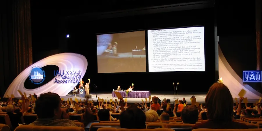 Astronomers raise their voting cards at the International Astronomical Union's General Assembly in Prague, 24 August 2006