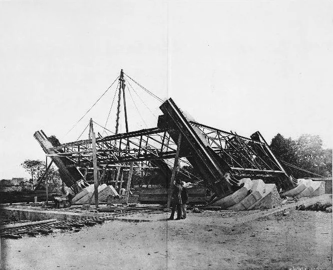The Eiffel Tower's iron legs rising towards the first platform in the early stages of construction.