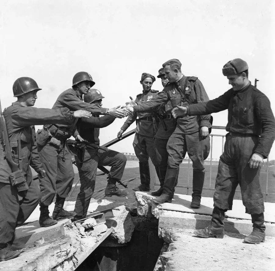 American and Soviet soldiers meet on the broken bridge at Torgau on the Elbe, April 1945.