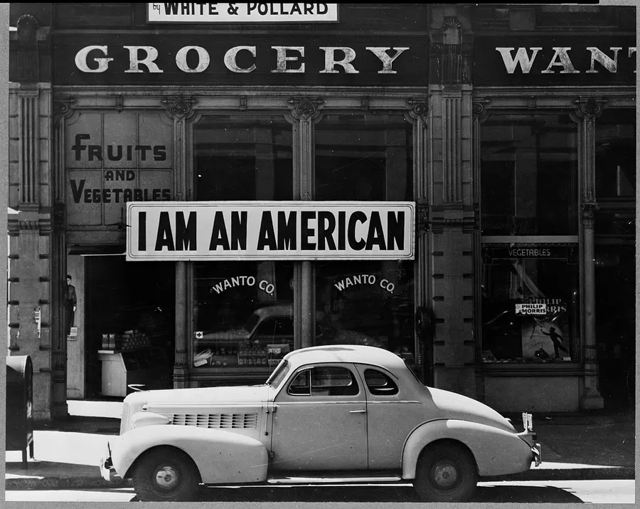 An 'I am an American' sign in the window of a Japanese American grocery in Oakland, California, photographed by Dorothea Lange in March 1942 after the owner was ordered to leave.