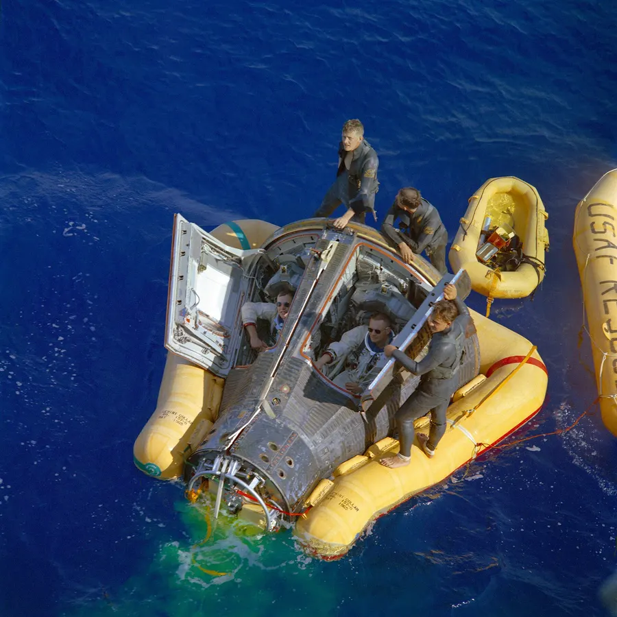 David Scott and Neil Armstrong in their Gemini 8 capsule after splashdown on 16 March 1966, with Air Force rescuers.