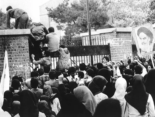 Iranian students climb the gates of the US embassy in Tehran, 4 November 1979.