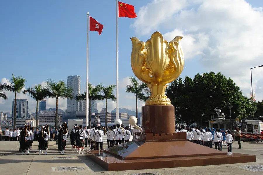 The golden bauhinia sculpture in Golden Bauhinia Square, Hong Kong, a gift from the Chinese government to mark the handover, with the flags of China and Hong Kong behind it
