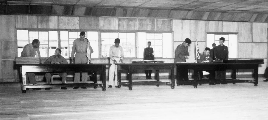 General William Harrison (seated left) and General Nam Il (seated right) sign the armistice at Panmunjom on 27 July 1953