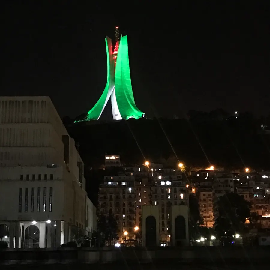 The Martyrs' Memorial (Maqam Echahid) in Algiers, lit at night in the green, white and red of the Algerian flag