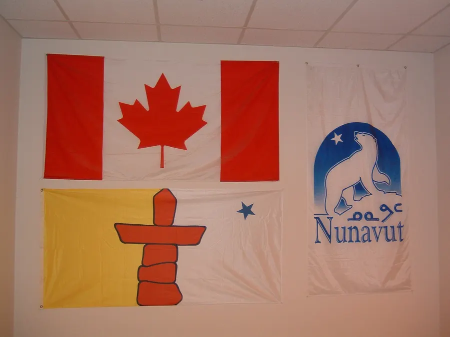 The flags of Canada and Nunavut hung beside a Nunavut banner