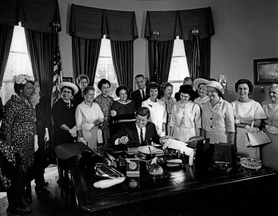 Members of the American Association of University Women watch President Kennedy sign the Equal Pay Act