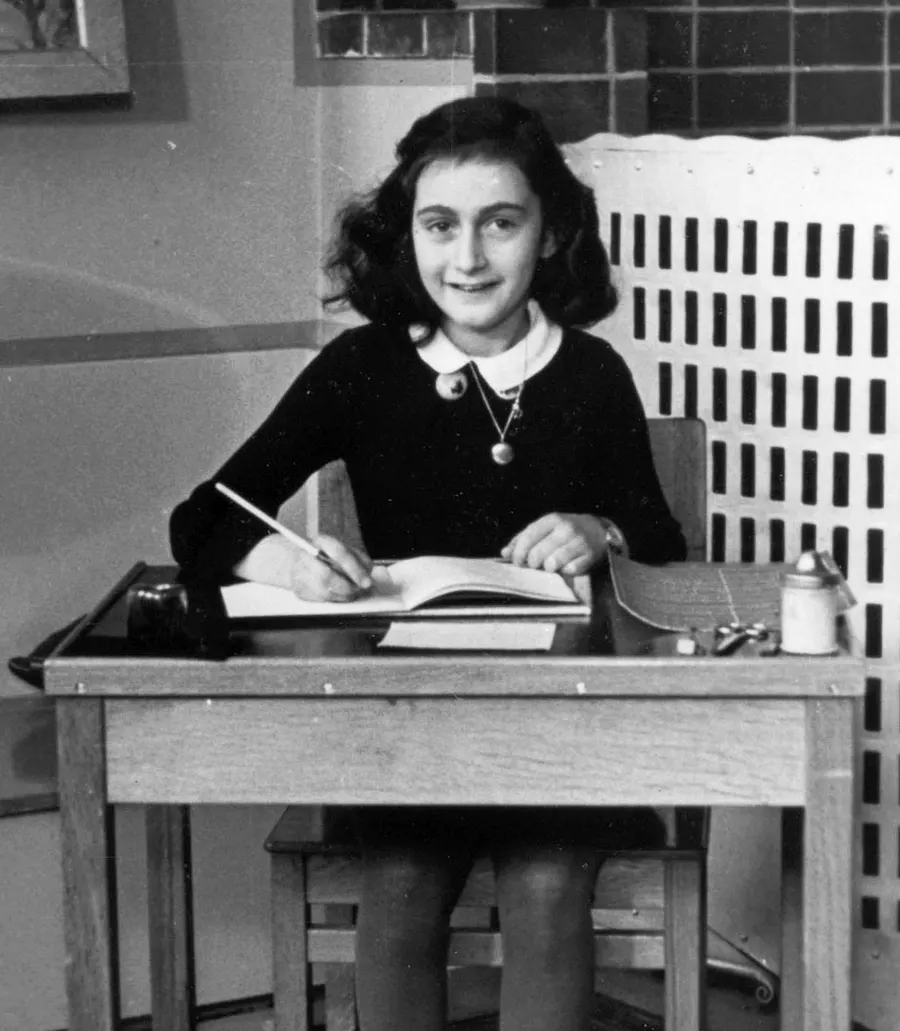 Anne Frank writing at a desk in 1940, two years before she was given her diary