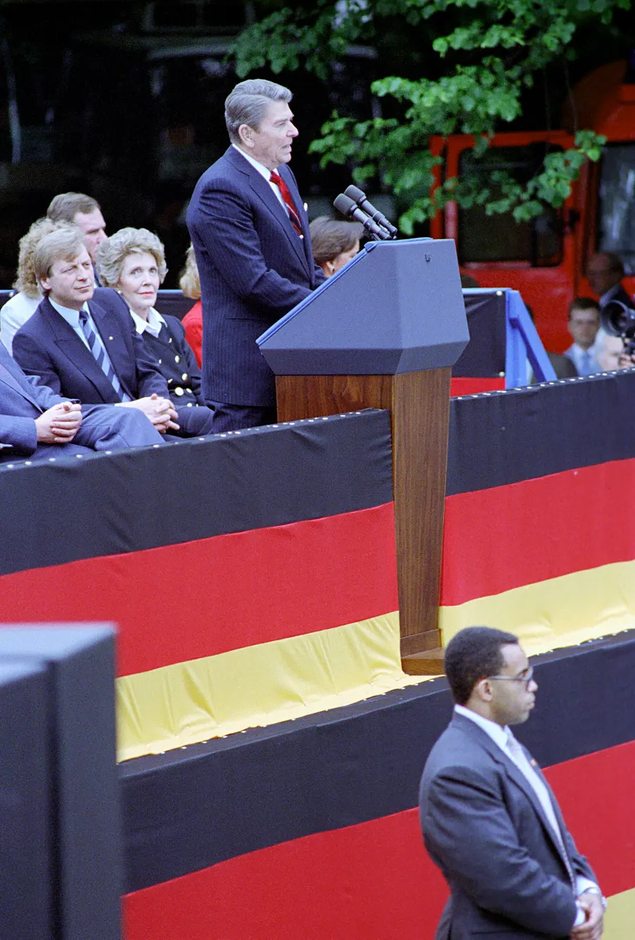 President Reagan speaking at the Brandenburg Gate in West Berlin, with Nancy Reagan and Berlin's mayor Eberhard Diepgen on the platform