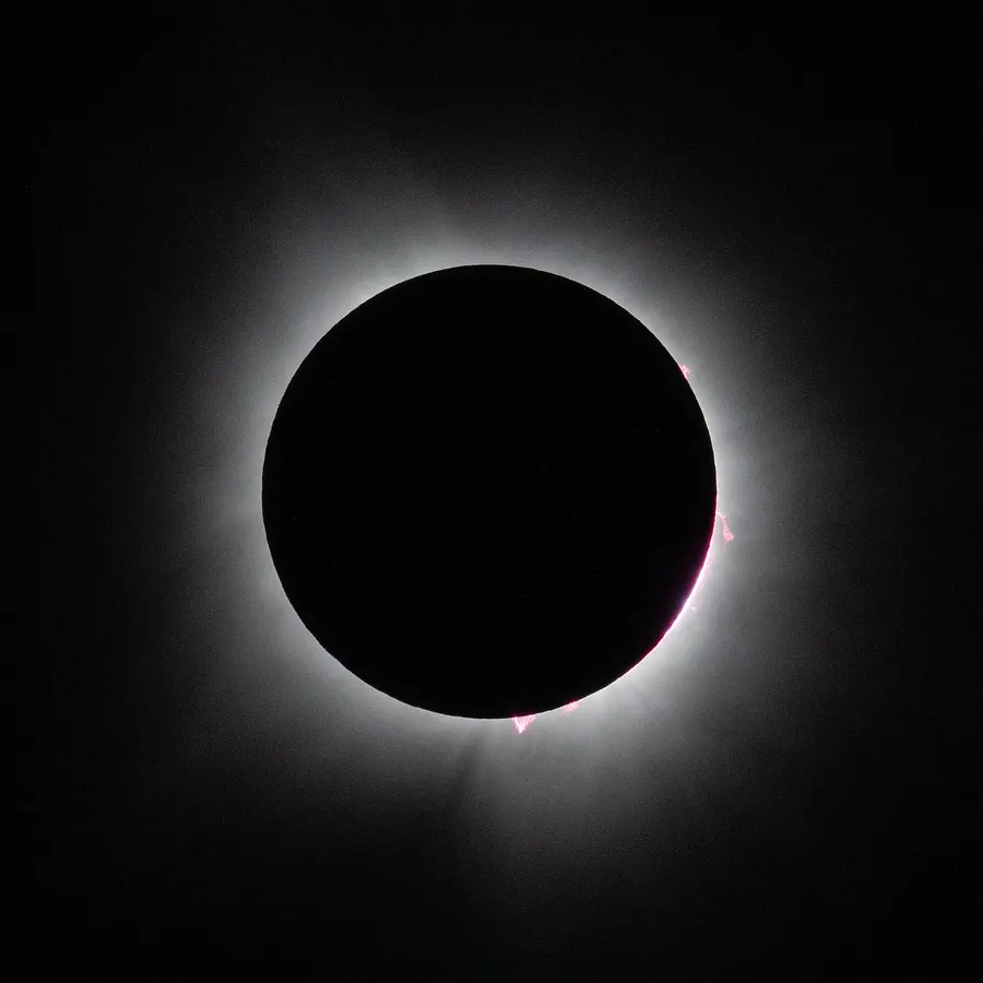 A total eclipse of the Sun, with the corona shining around the Moon's disc, photographed in 2024