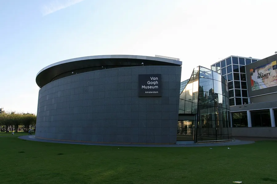 The Van Gogh Museum in Amsterdam at dusk, with the later oval exhibition wing in front