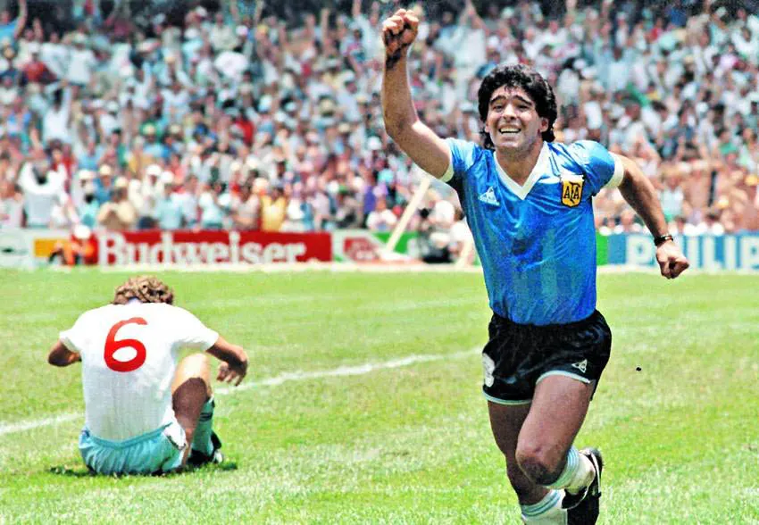Diego Maradona celebrates his second goal against England at the Estadio Azteca, as England defender Terry Butcher sits on the pitch