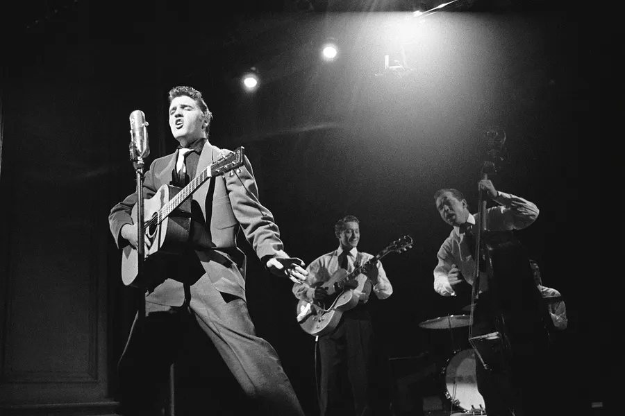 Elvis Presley performing on stage with his band in 1956, from TV Radio Mirror magazine