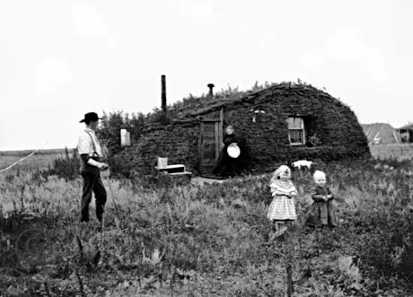 A homesteading family outside their sod house in North Dakota