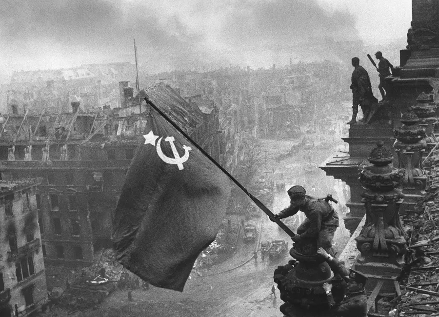 Yevgeny Khaldei's photograph of a Soviet soldier raising a flag over the Reichstag in Berlin, taken on 2 May 1945.