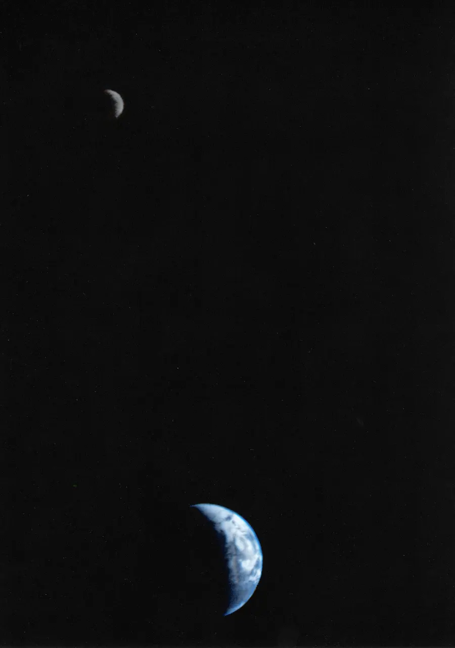 The crescent Earth and Moon, photographed together by Voyager 1 on 18 September 1977; the Moon, at the top, has been brightened so that both can be seen