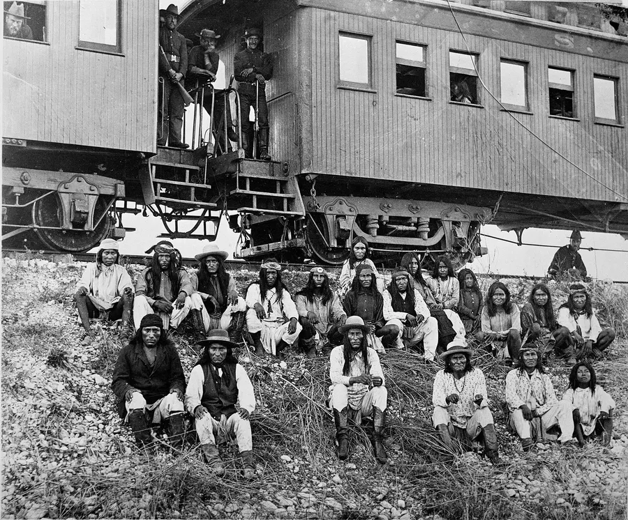 Geronimo (third from the right, in front) and other Apache prisoners beside the Southern Pacific Railway near the Nueces River, Texas, on 10 September 1886, on their way to exile in Florida