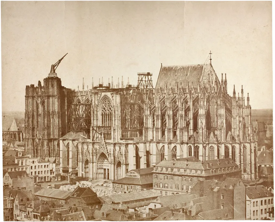 Cologne Cathedral under construction in 1855, in an early salt-paper photograph, with the medieval crane still on the unfinished south tower